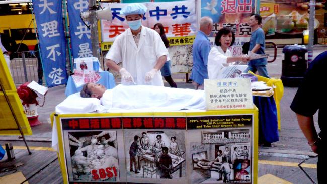 Người tu Pháp Luân Công mô phỏng cảnh mổ cướp nội tạng trên đường phố Hồng Kông. (Ảnh: Cory Doctorow/Flickr)