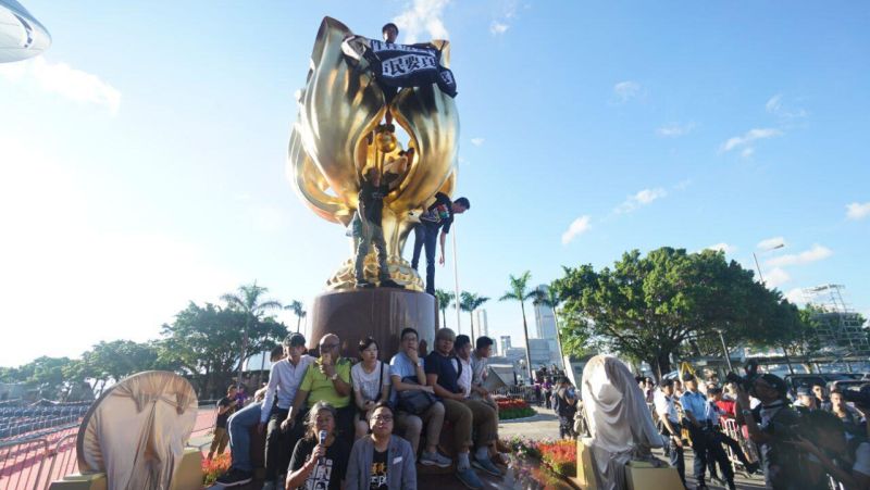 Người biểu tình ngôi xung quanh và trèo lên tượng Kim Tử Kinh