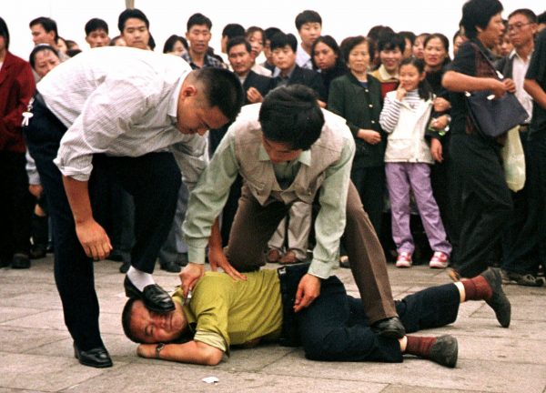 Cảnh sát bắt giữ một người biểu tình Pháp Luân Công tại Quảng trường Thiên An Môn ở Bắc Kinh vào ngày 1/10/2000. 