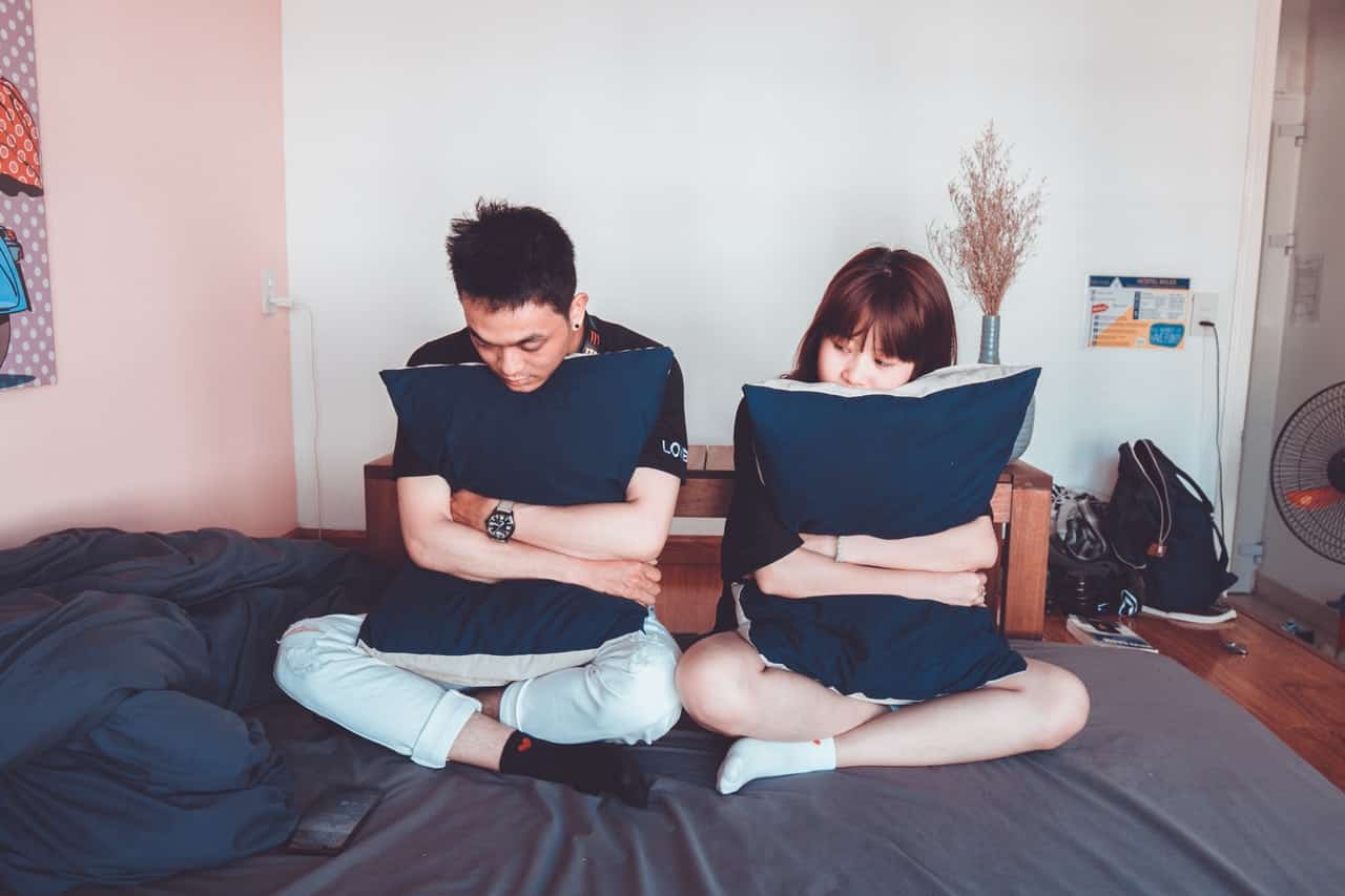 man and woman sitting on bed 1057022