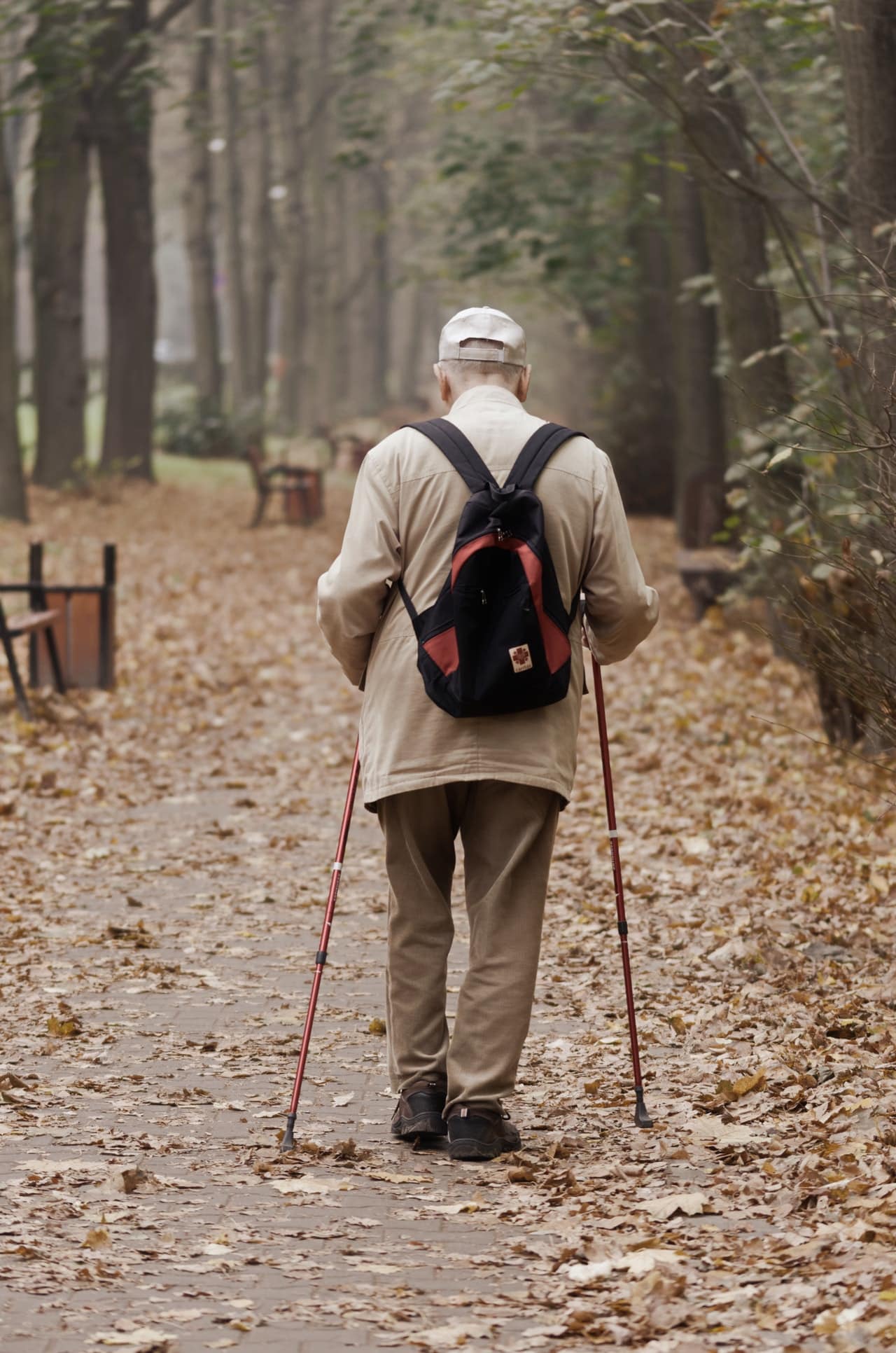 man carrying backpack while walking on a paved pathway 3149407 image