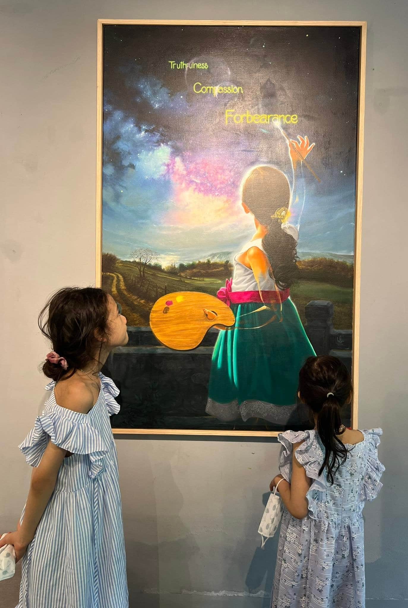Hai em nhỏ đang xem bức tranh Điều Kỳ Diệu (Sơn dầu trên vải; 1m50 x 95cm) của Họa sĩ Nguyễn Minh Nam tại triển lãm Ưu Đàm, Hà Nội, 2022.